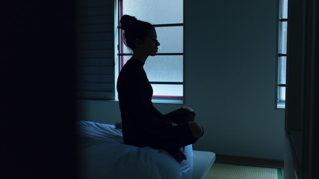 κατάθλιψη στις γυναίκες γυναίκα κάνει διαλογισμό στο κρεββάτι