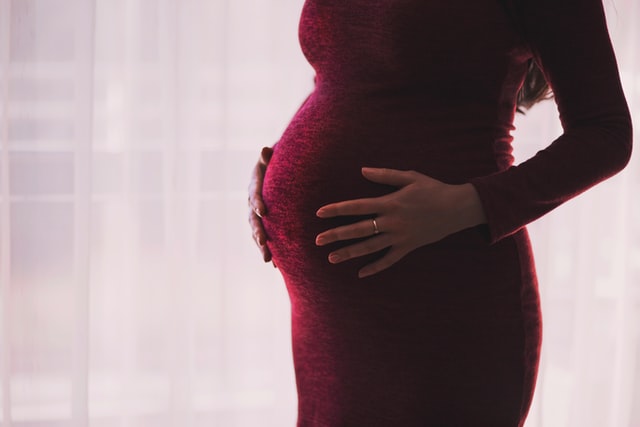 επιλόχειος κατάθλιψη έγκυος γυναίκα με κόκκινο φόρεμα