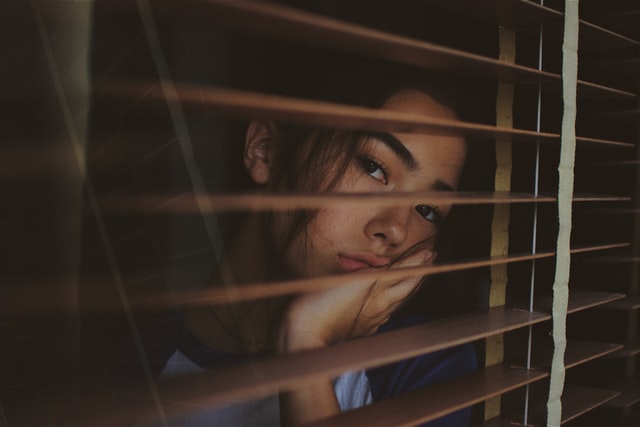 εποχική κατάθλιψη κοπέλα θλιμμένη κοιτάζει από το παράθυρο