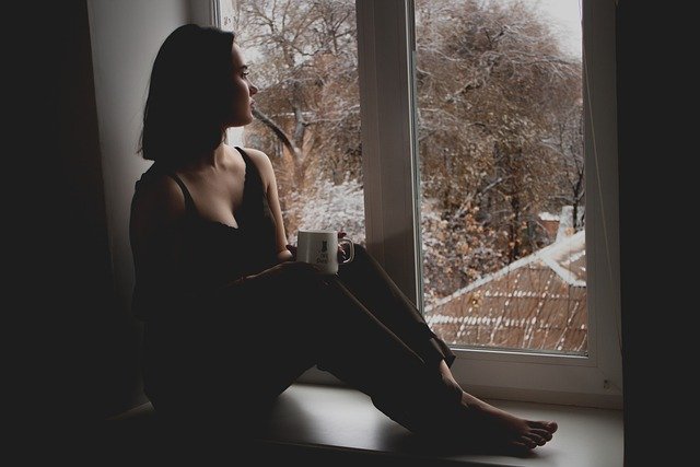 χωρισμός ενώ υπάρχει αγάπη γυναίκα κάθεται στο παράθυρο και πίνει καφέ