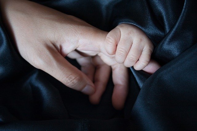σημάδια αυτισμού σε μωρό παιδί πιάνει το δάχτυλο της μαμάς του