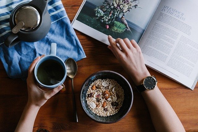 νευρική ορθορεξία άνδρας τρώει πρωινό με καφέ και δημητριακά ενώ διαβάζει ένα περιοδικό